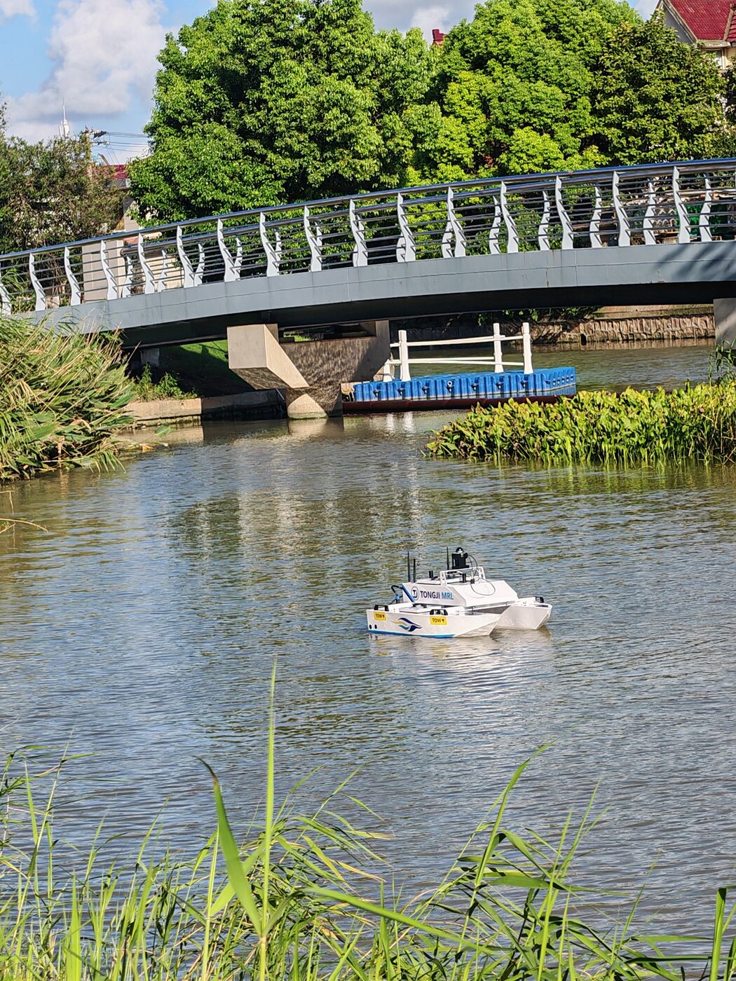 Tongji MRL USV moving across a pond near a pedestrian bridge